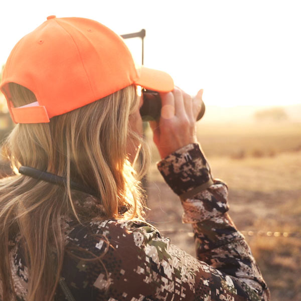 woman hunting and looking through binoculars